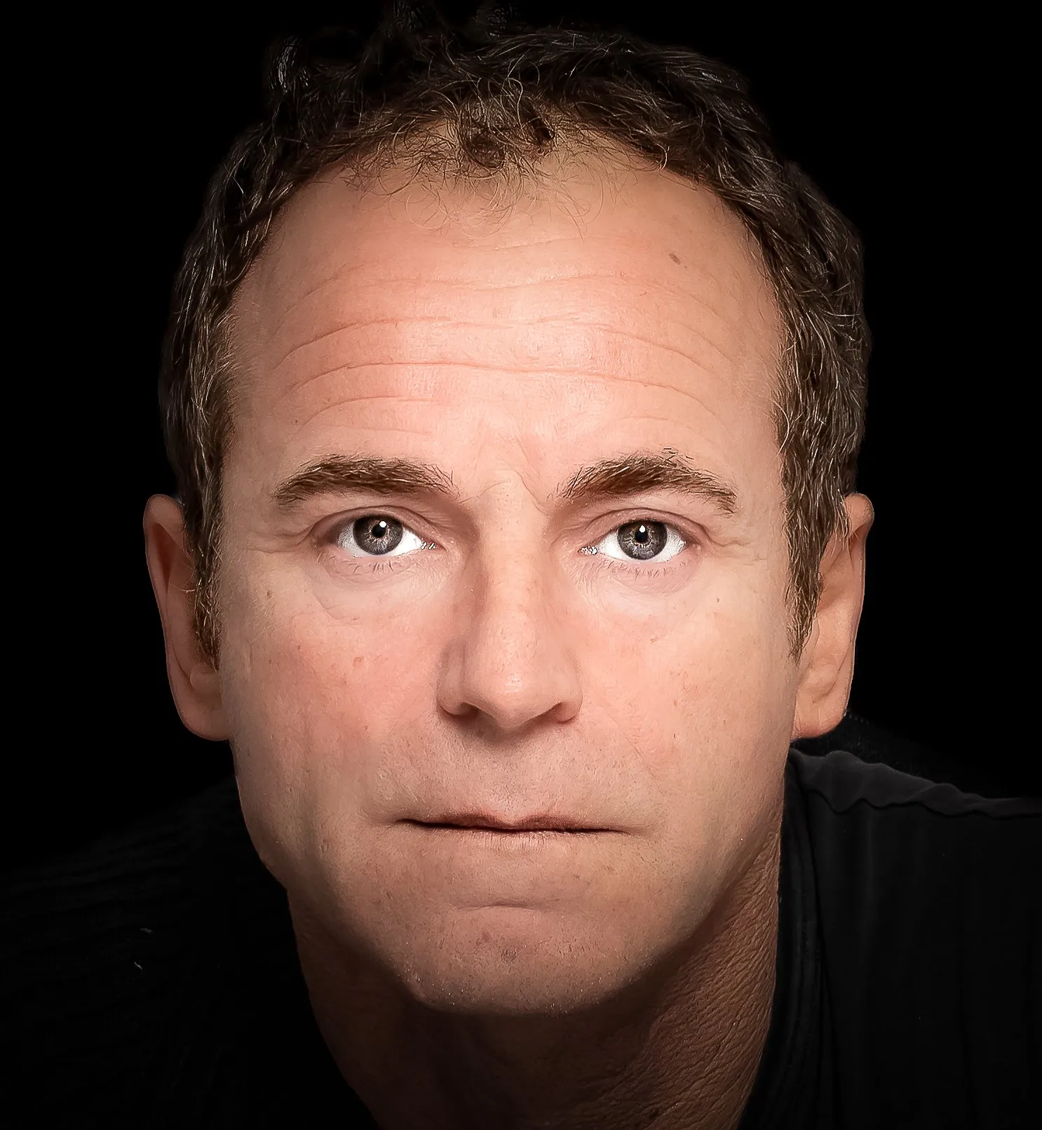 Uomo dallo sguardo fermo su fondo nero