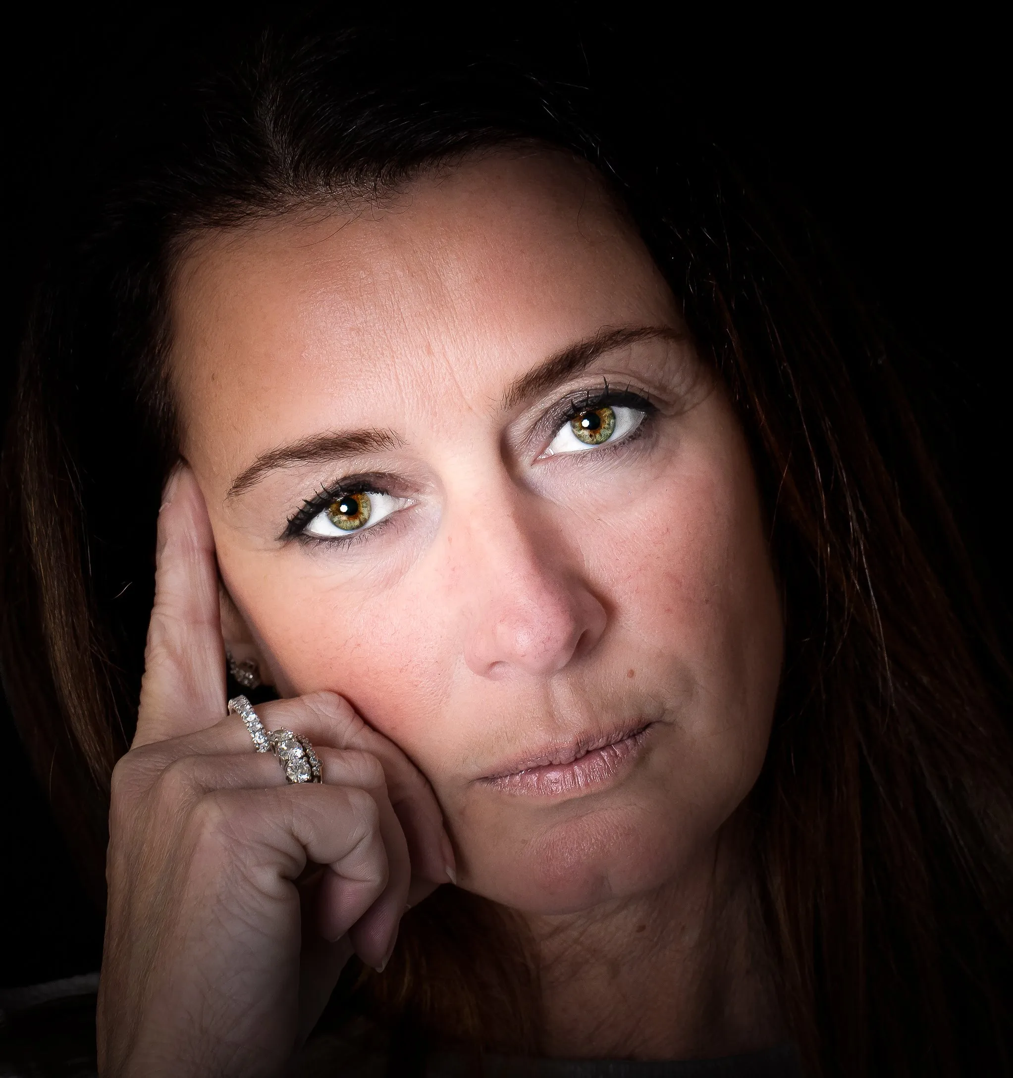 Donna con la mano sul viso e occhi verdi