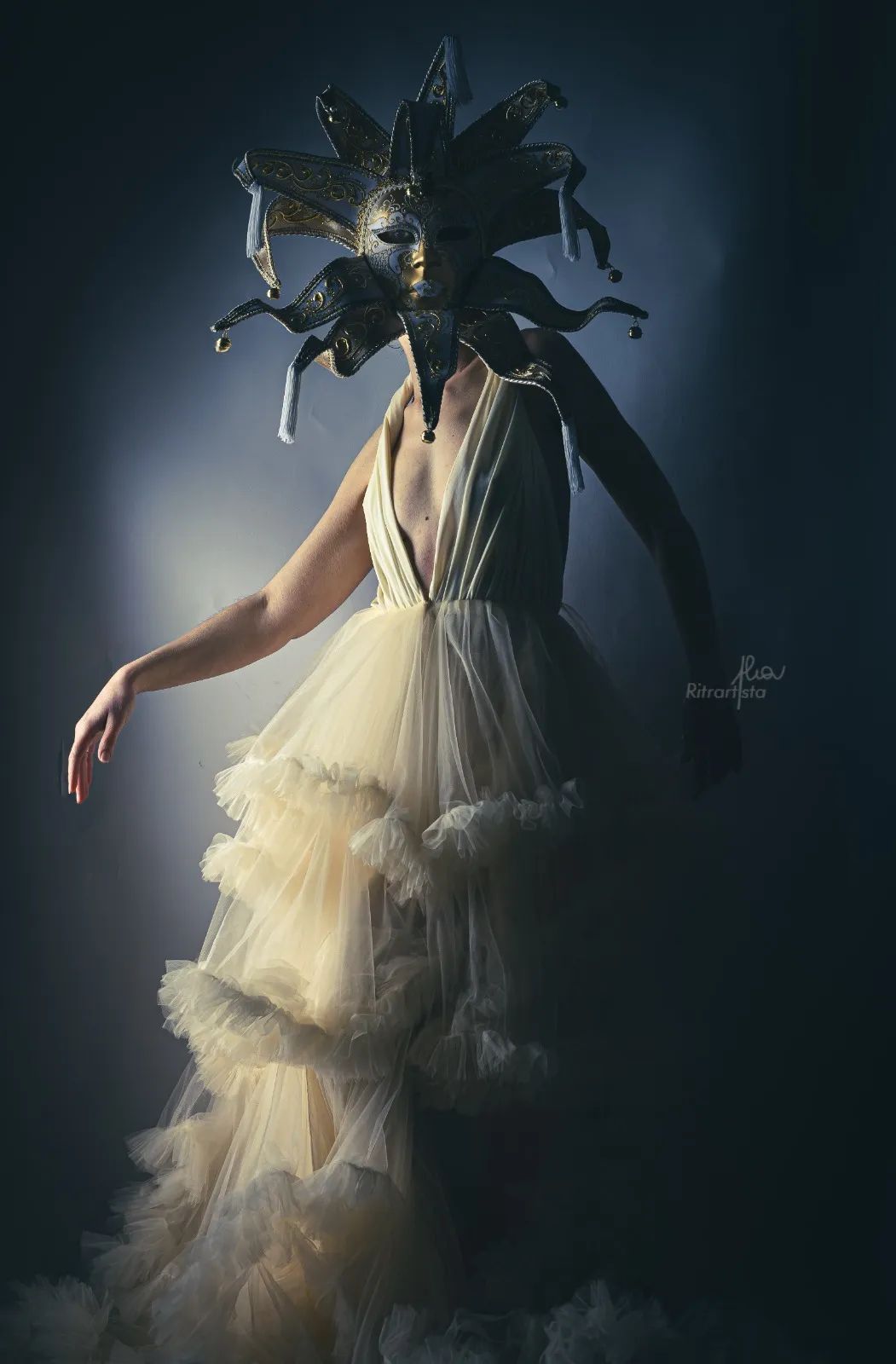 Figura con maschera veneziana e abito di tulle avorio, su fondo blu
