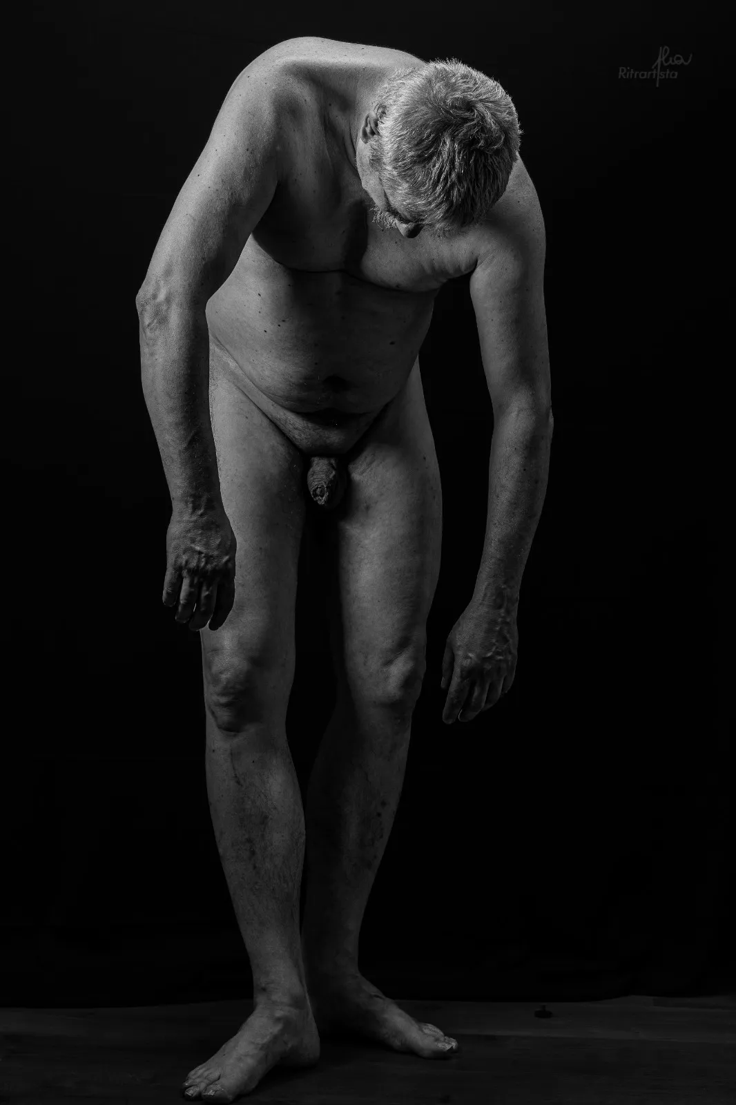 Nudo maschile in bianco e nero su fondo nero